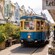 Car number 1888 of the Christchurch Tram operating on the city tour by shopfronts and outdoor seating areas